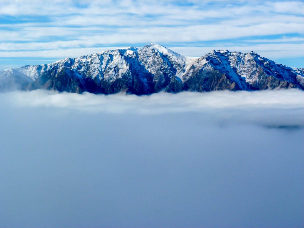 Gipfel hinter der Wolkendecke über Lake Hawea